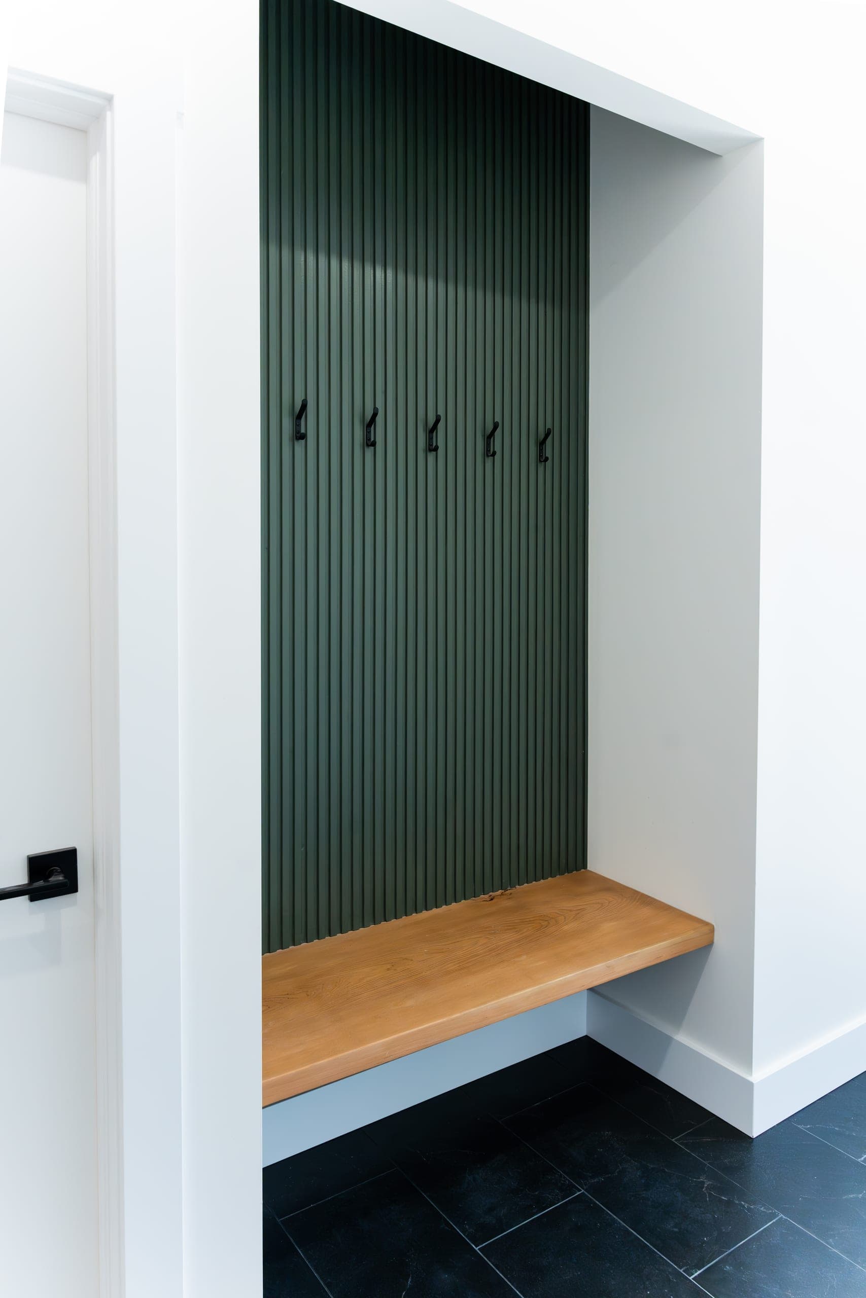 Mudroom feature wall with green fluted panel and bench seat