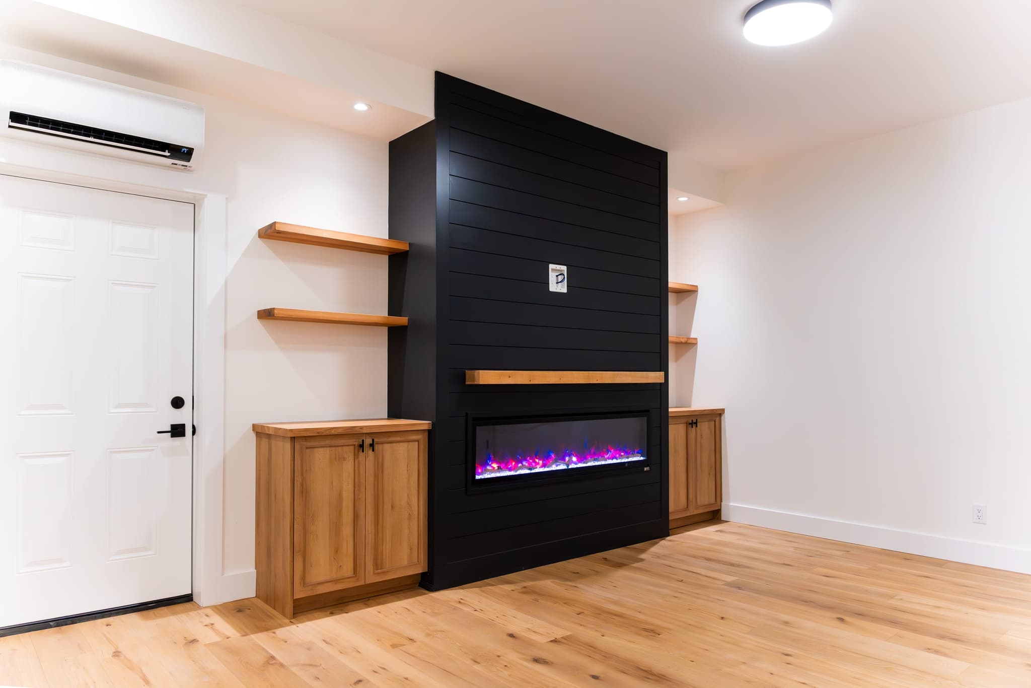Black shiplap electric fireplace with timber mantel