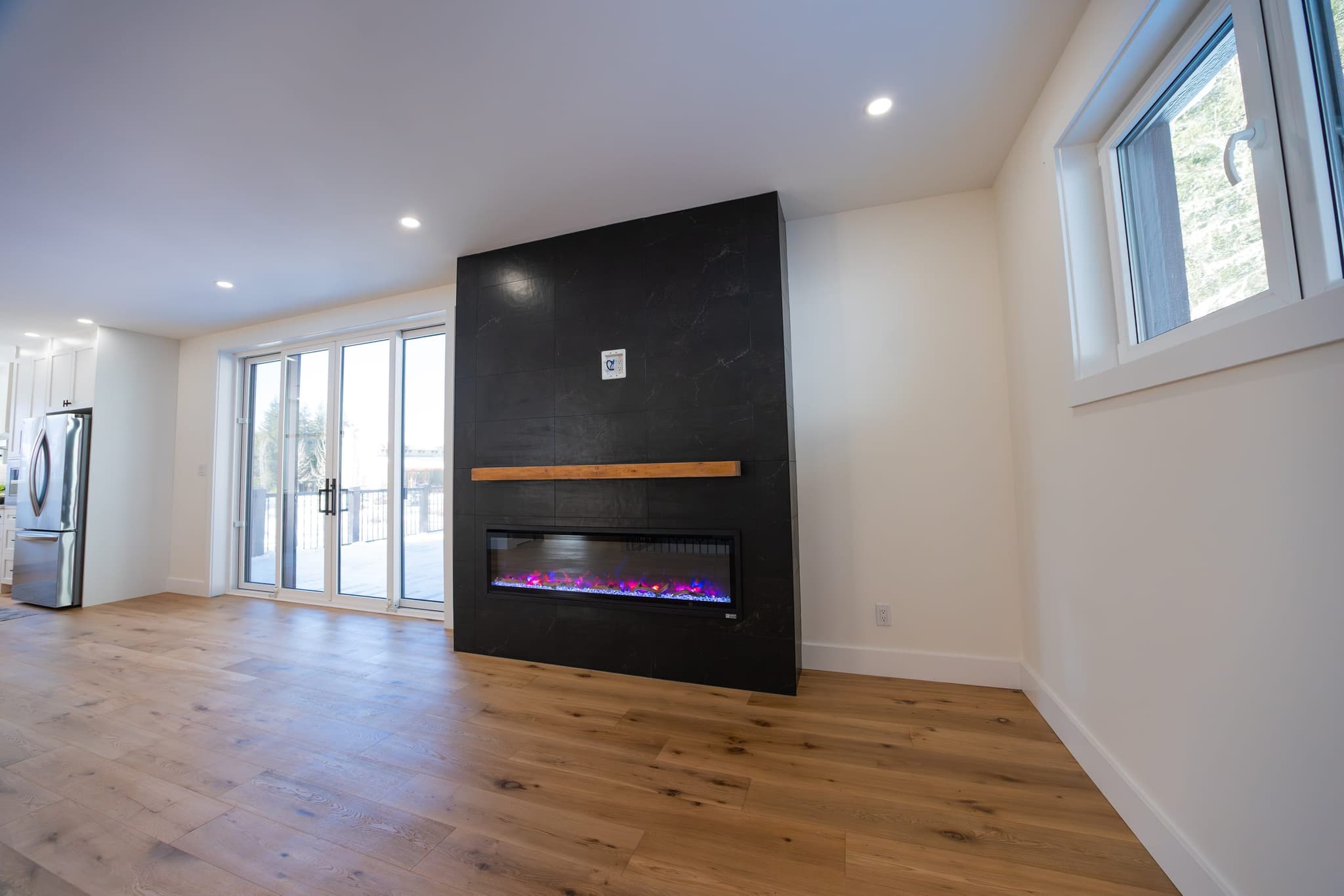 Great room fireplace clad in dark stone tile