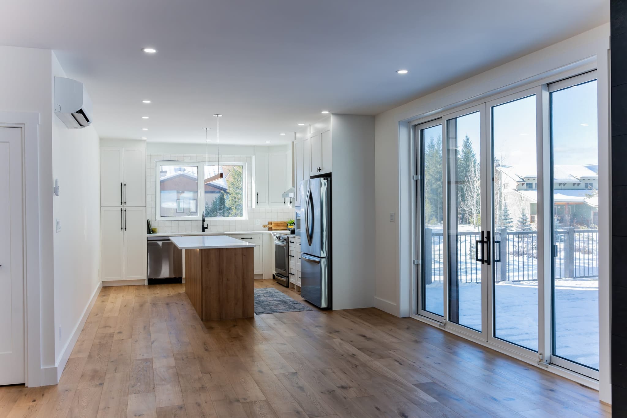 Bright kitchen with white cabinets, wood island and patio doors