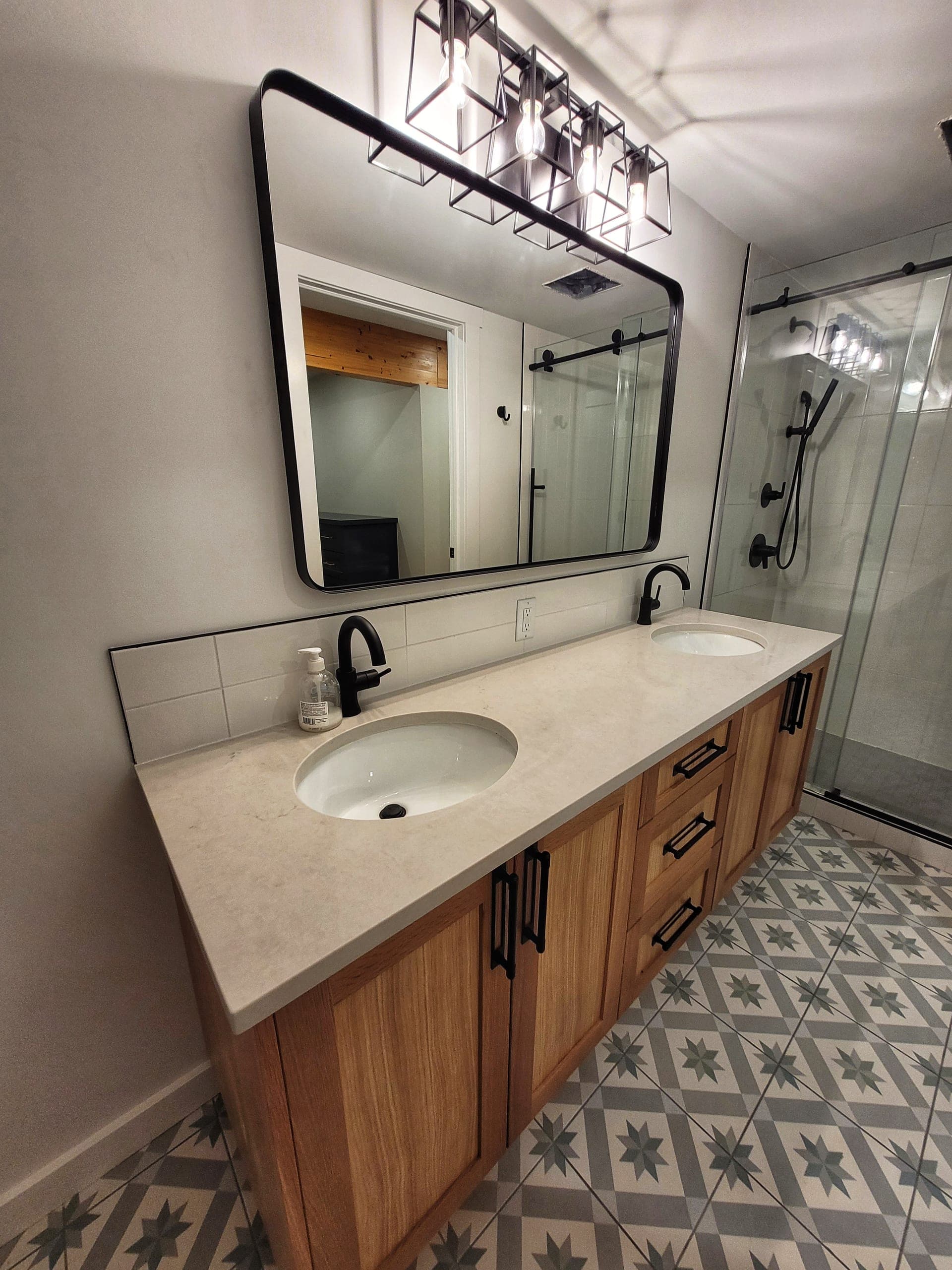 Custom cottage bathroom with double vanity and patterned tile floor