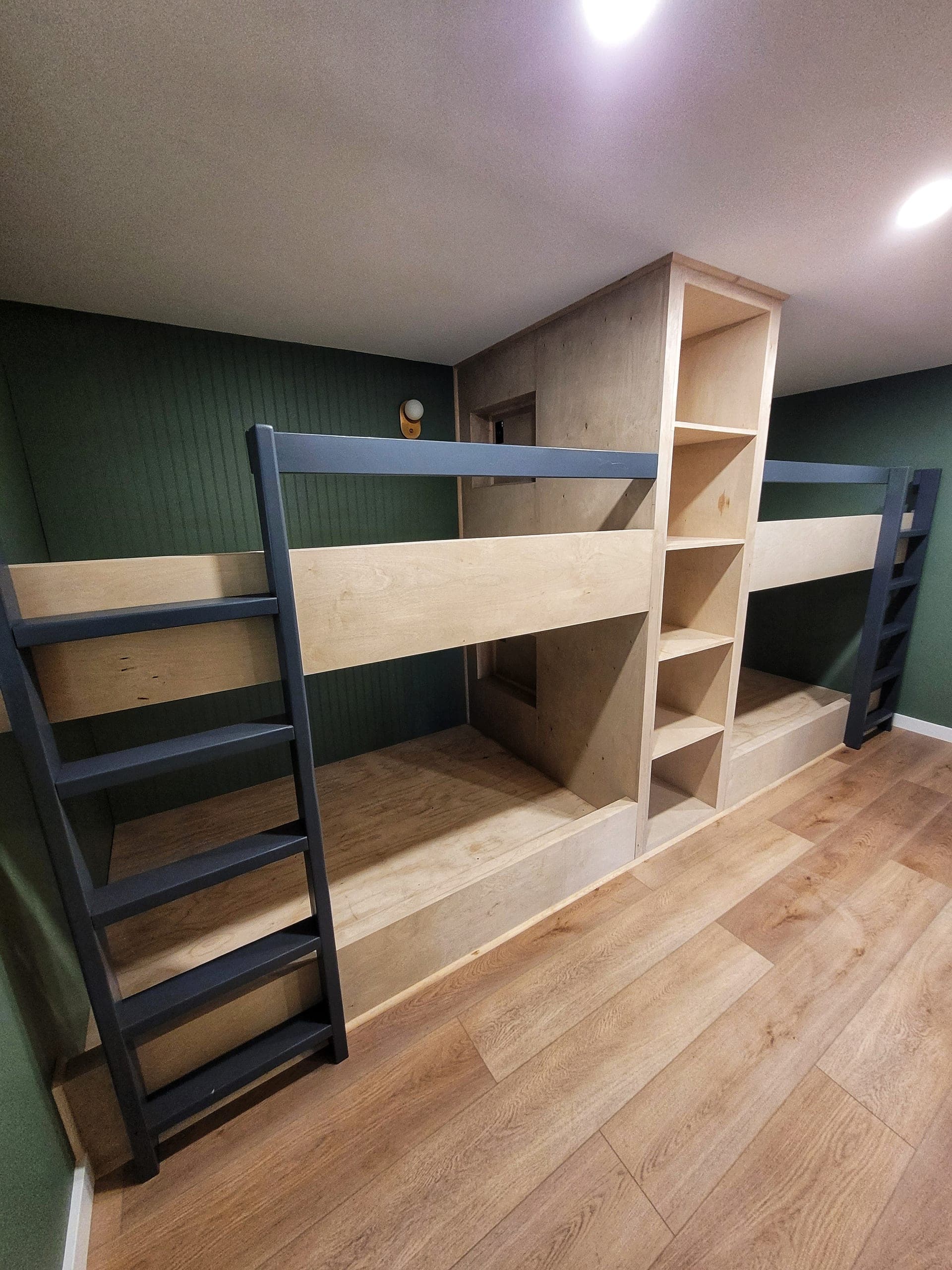 Custom-built bunk room with built-in shelves and ladders