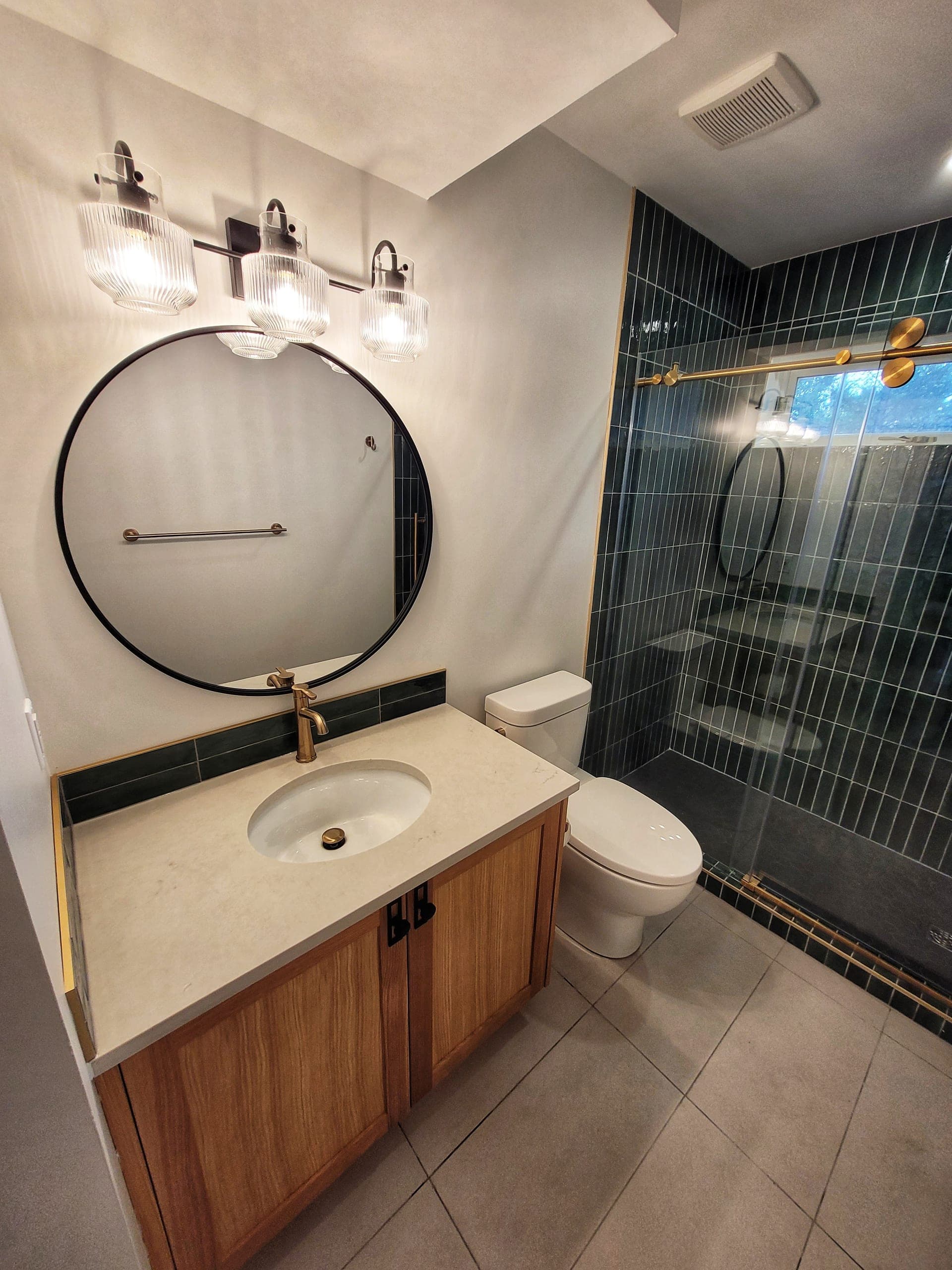Cottage ensuite with teal subway shower and brass fixtures