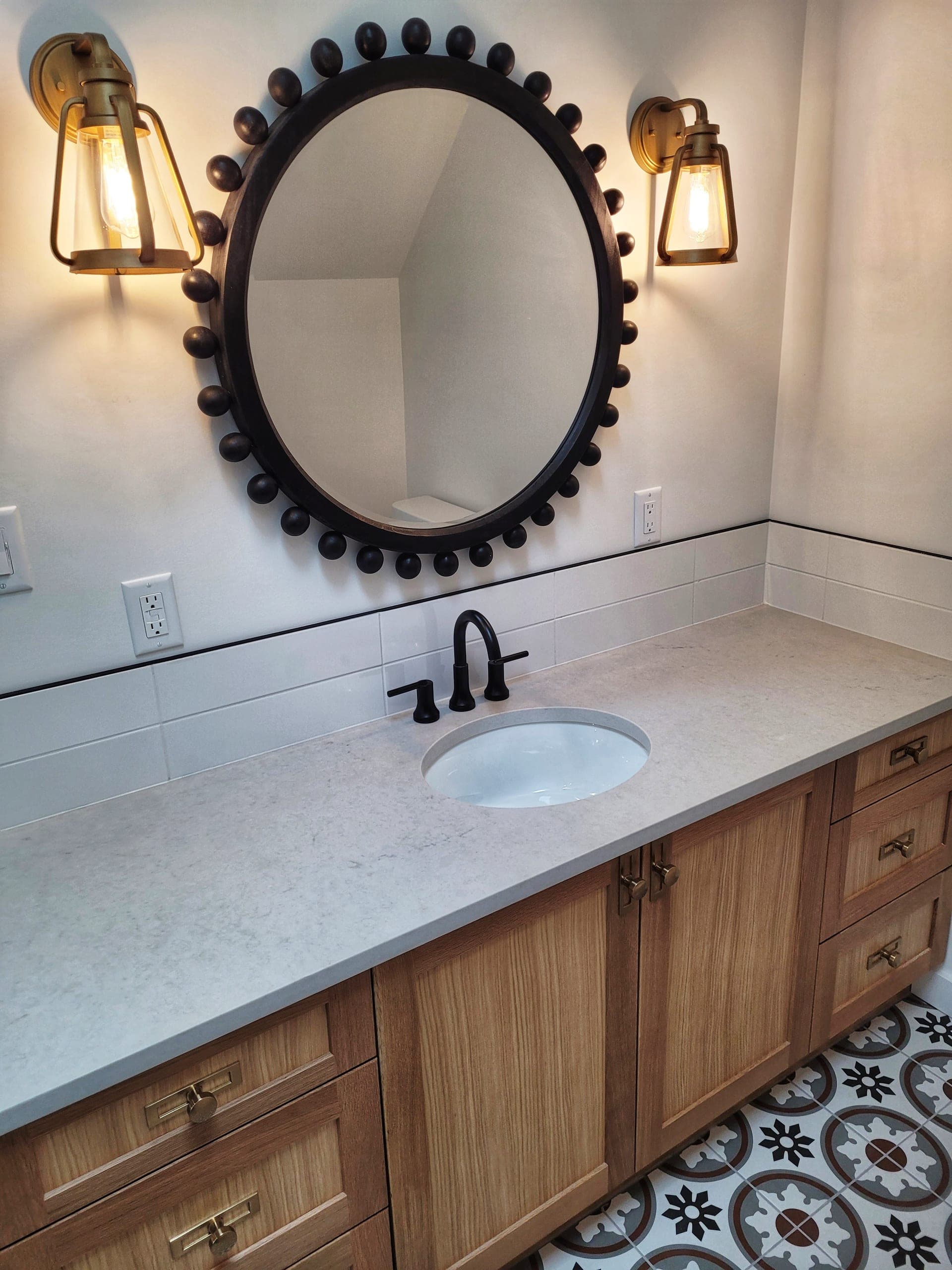 Custom vanity with beaded round mirror and brass sconces