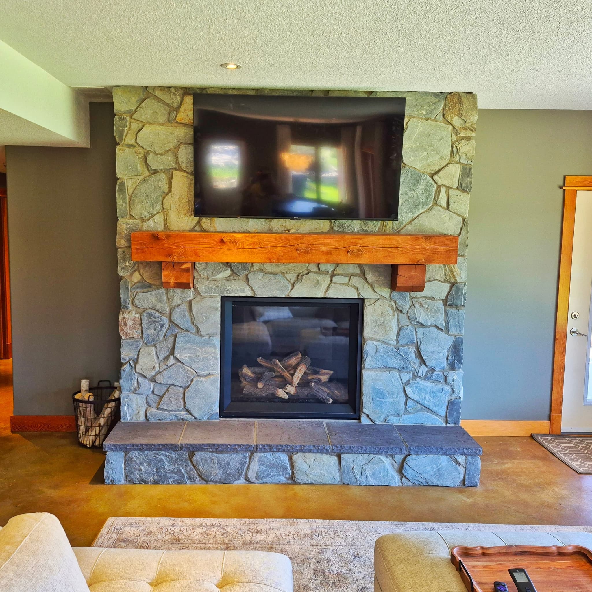 Open great room with vaulted ceiling and custom finishes by Alpine View Construction